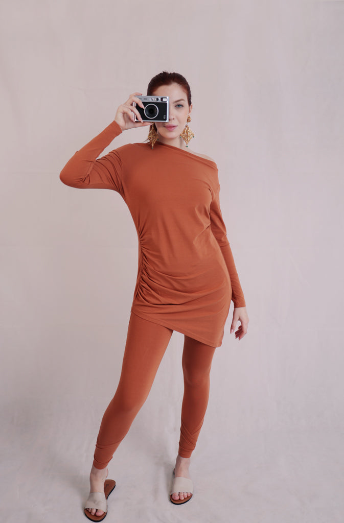 Solda TunicTopsThis sleek, long-sleeve tunic top features an off-the-shoulder design that accentuates your neckline and flatters the shoulders. The asymmetric bottom hem adds a touGlobalistinaSolda TunicGlobalistina